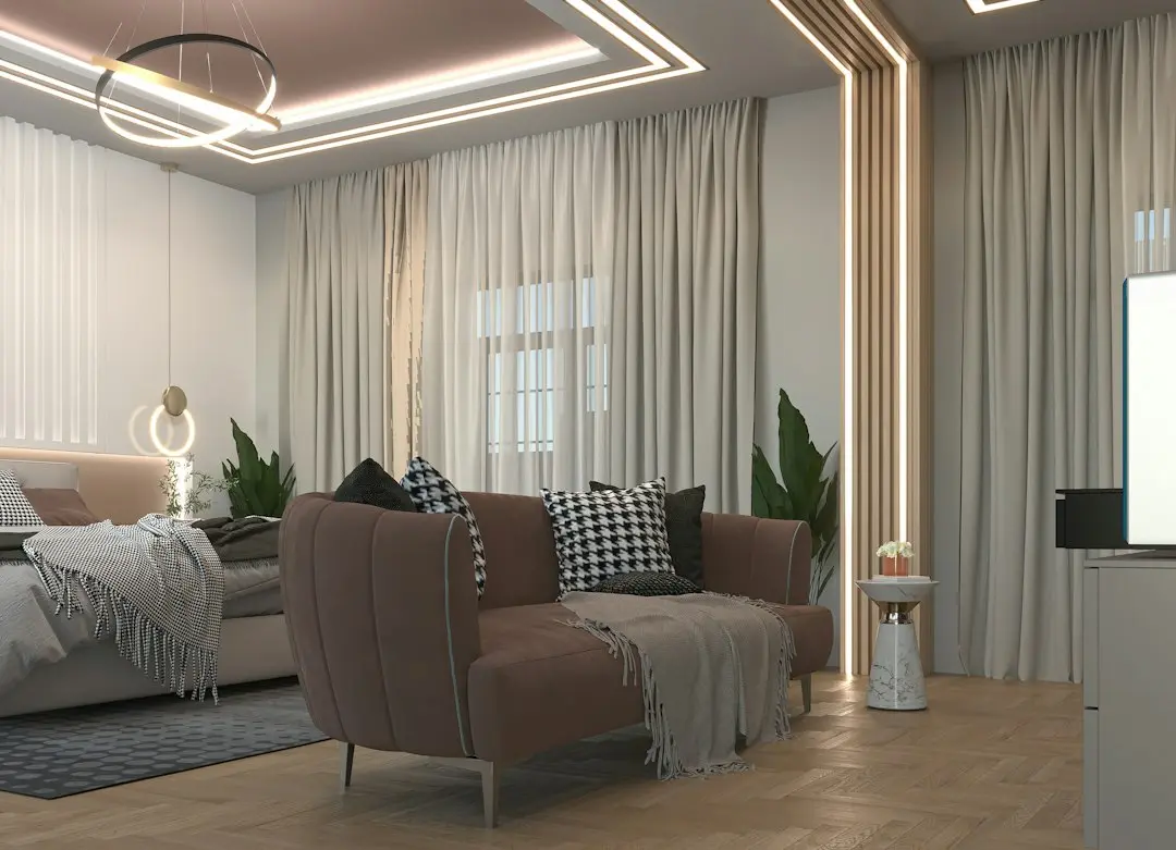 Modern living room with a brown sofa, patterned cushions and the edge of a TV on a white unit
